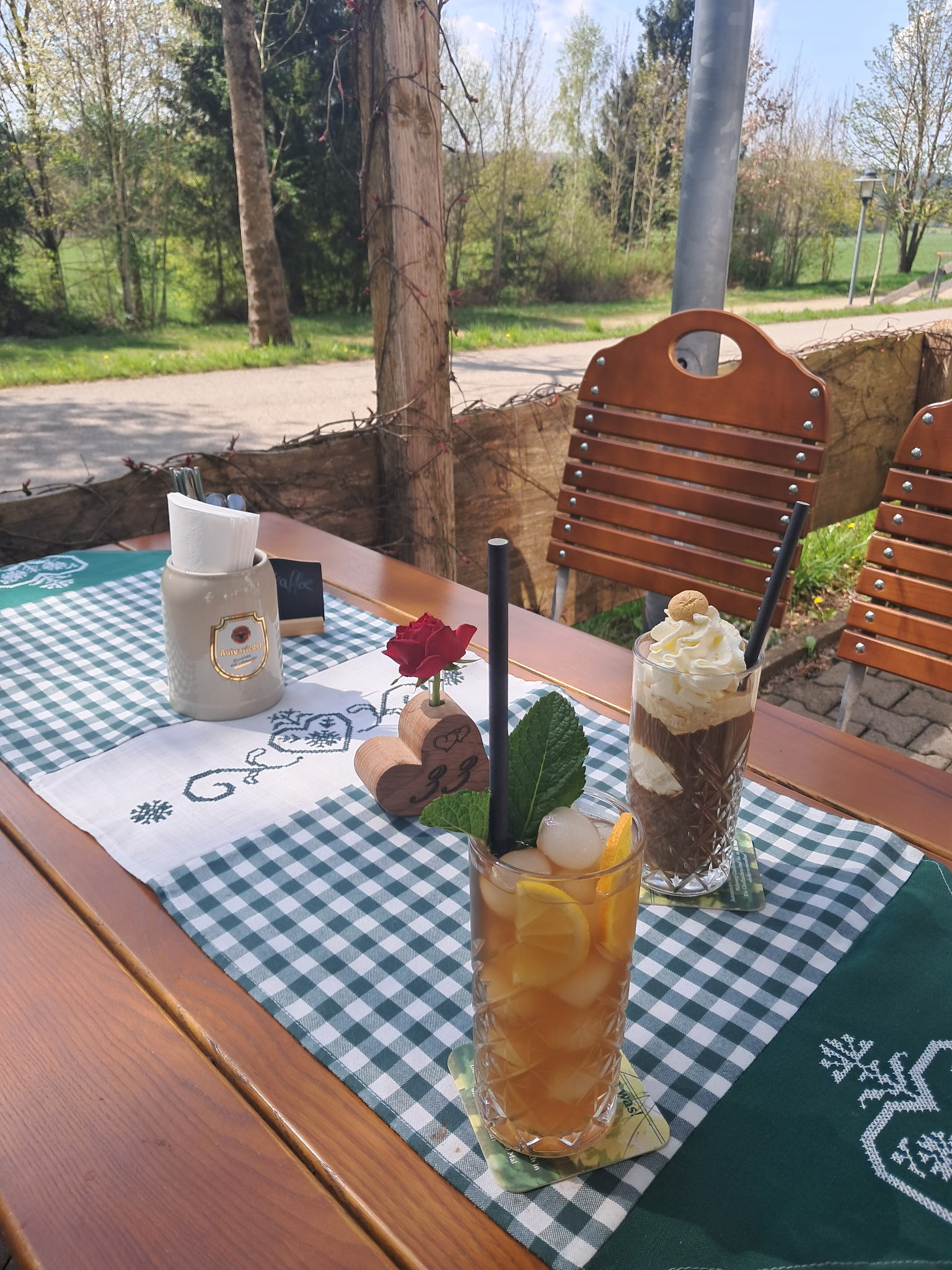 Gedeckter Tisch im Biergarten mit Getränken und Eisbecher